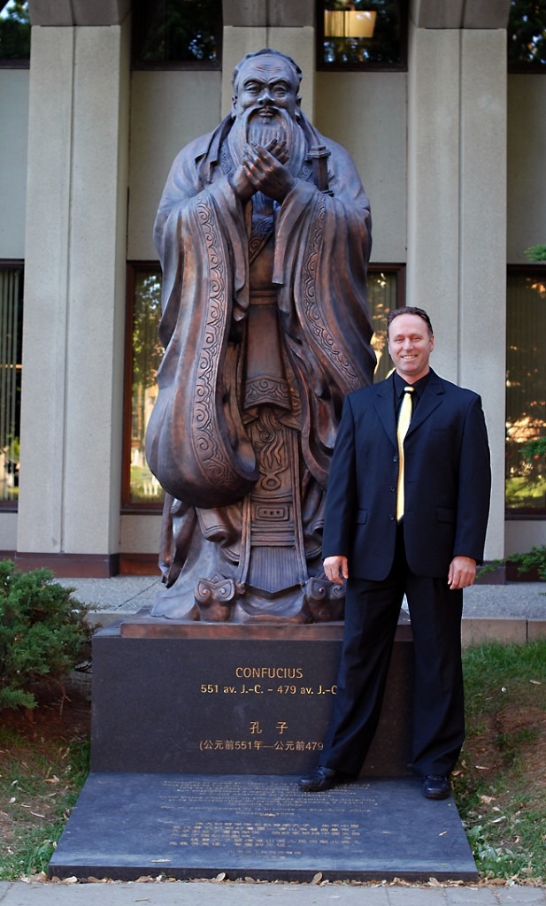 Sifu Alain Guébenne devant une statue de Confucius